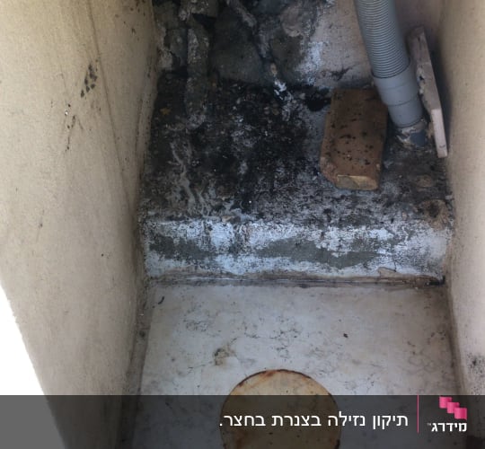 צינור גמיש ליד קיר עם טיח מתקלף
